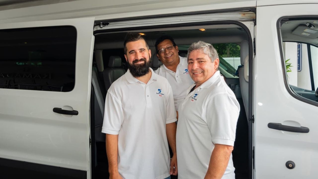 Professional chauffeur team standing outside a shuttle van.