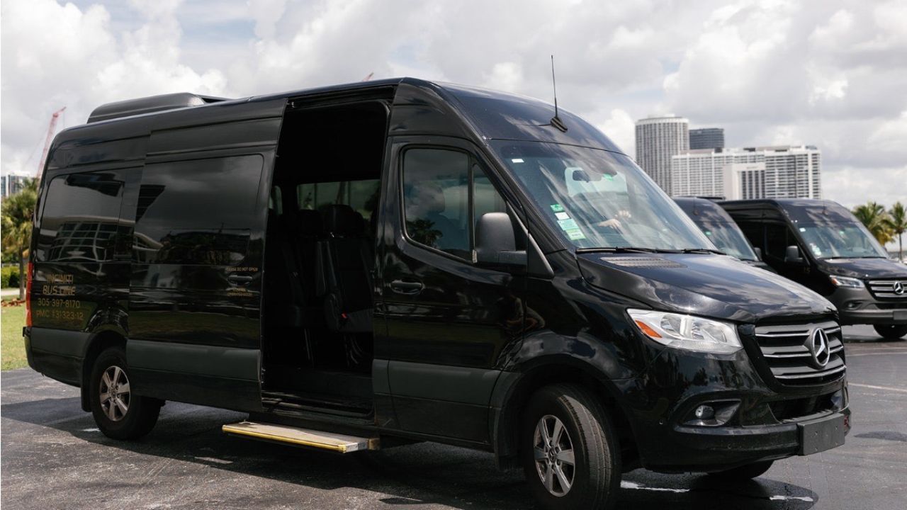 Luxury black shuttle van by System Shuttle Miami parked outdoors for group transportation.
