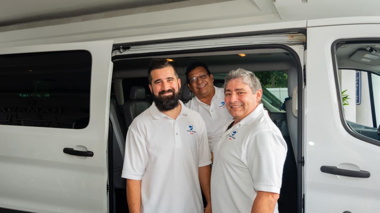 Three System Shuttle Miami staff members standing at the open door of a shuttle van