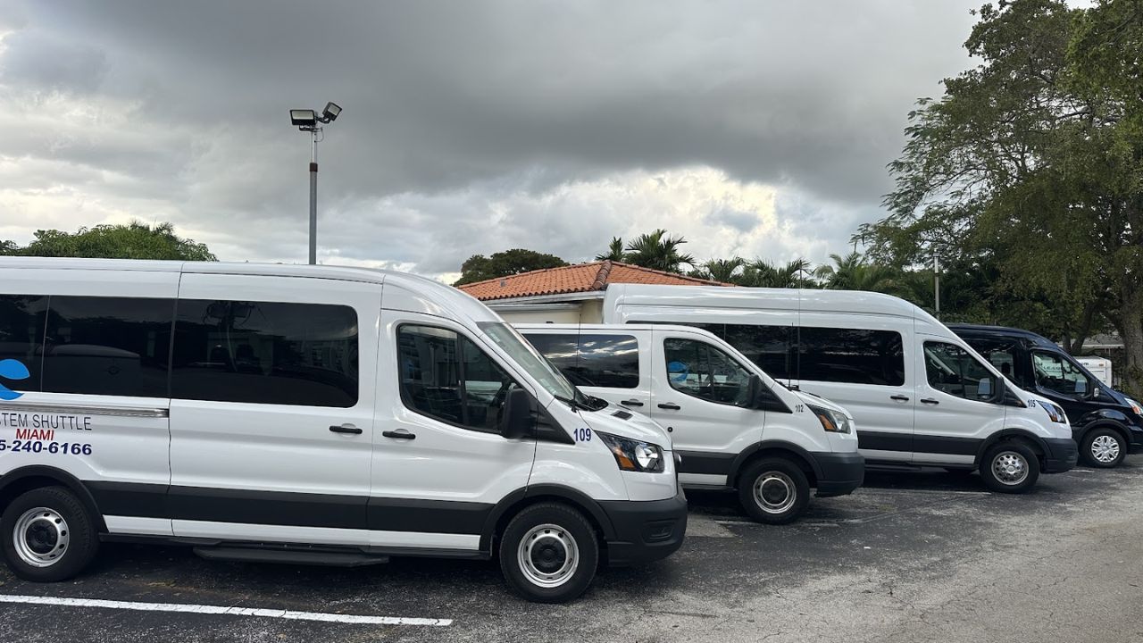 Row of System Shuttle Miami vans parked together 