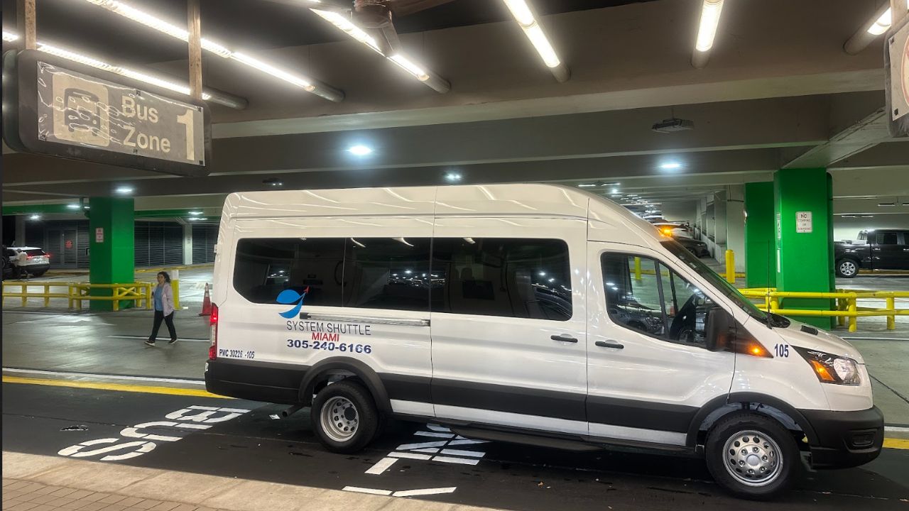 White System Shuttle Miami van parked in a bus zone area inside a parking garage