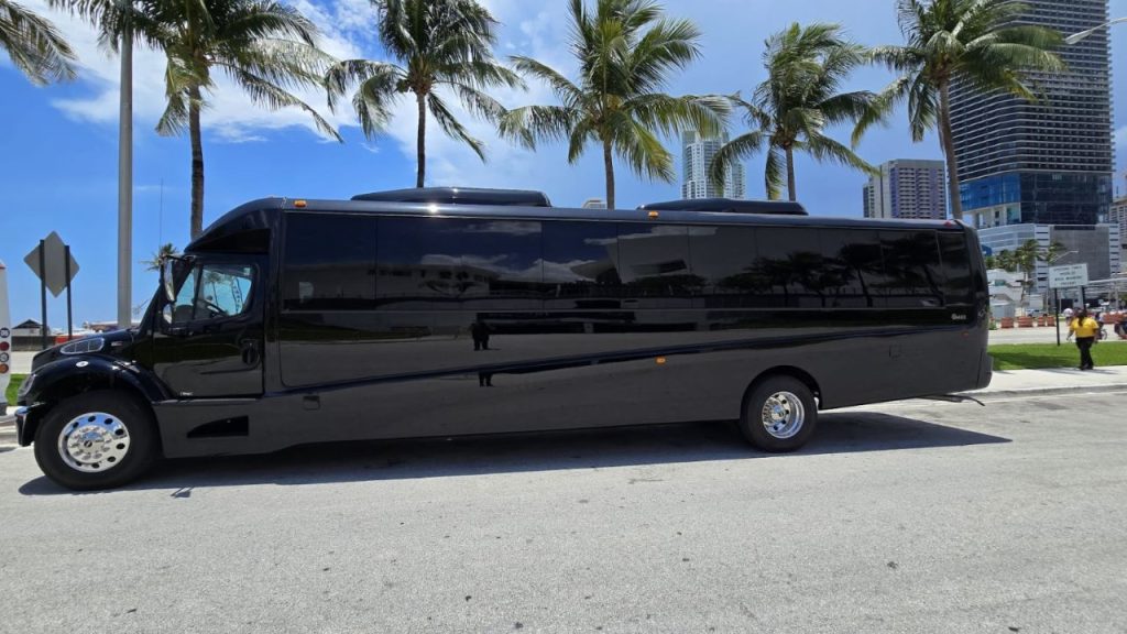 Black shuttle bus by System Shuttle Miami parked near palm trees in Miami
