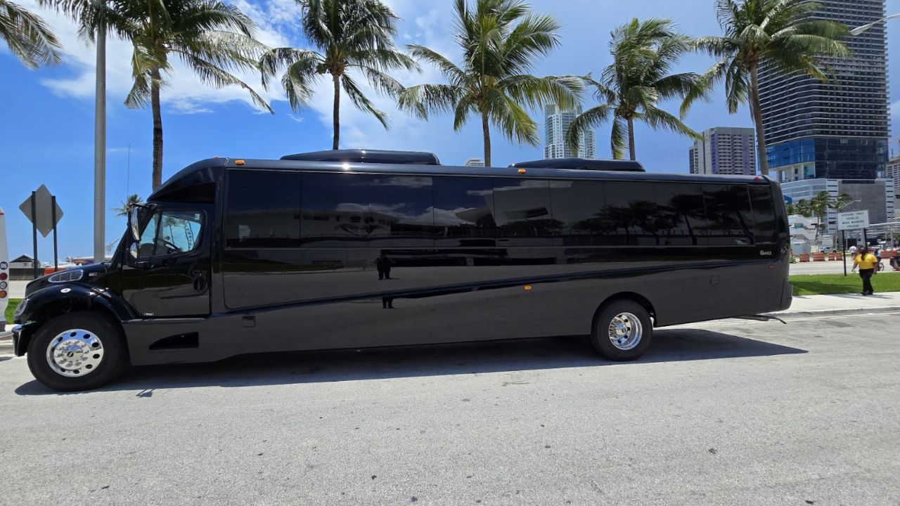 Black shuttle bus by System Shuttle Miami parked near palm trees in Miami

