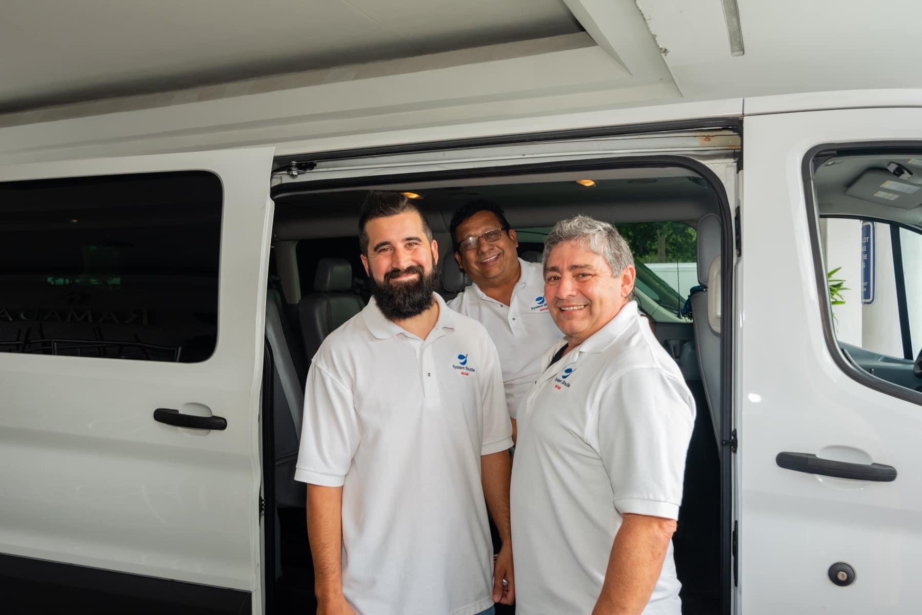 System Shuttle Miami team standing inside passenger van