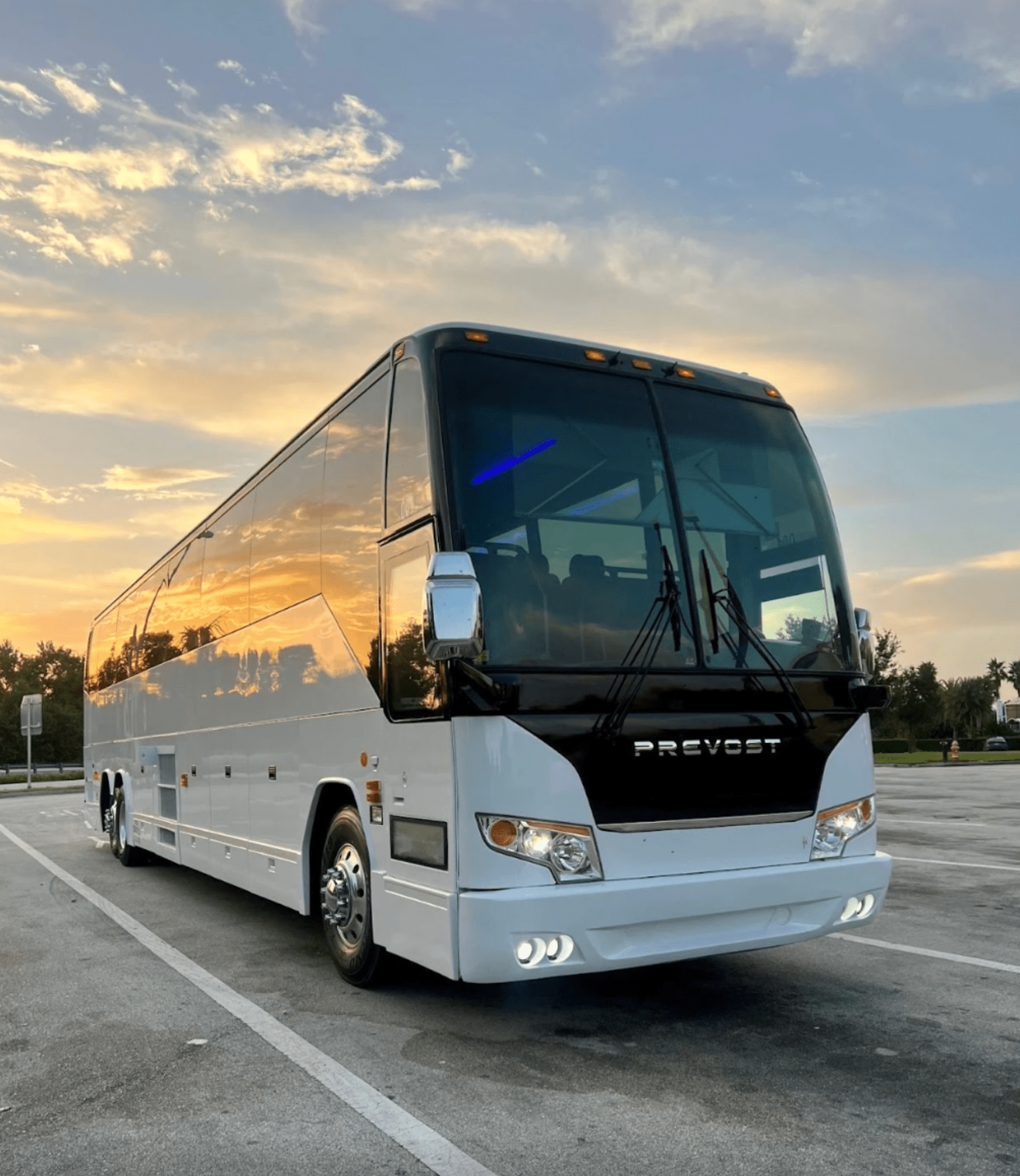 Luxury motor coach parked at sunset.