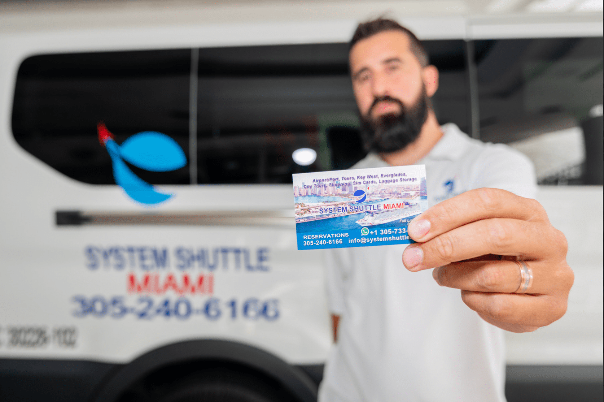 System Shuttle Miami representative holding business card.