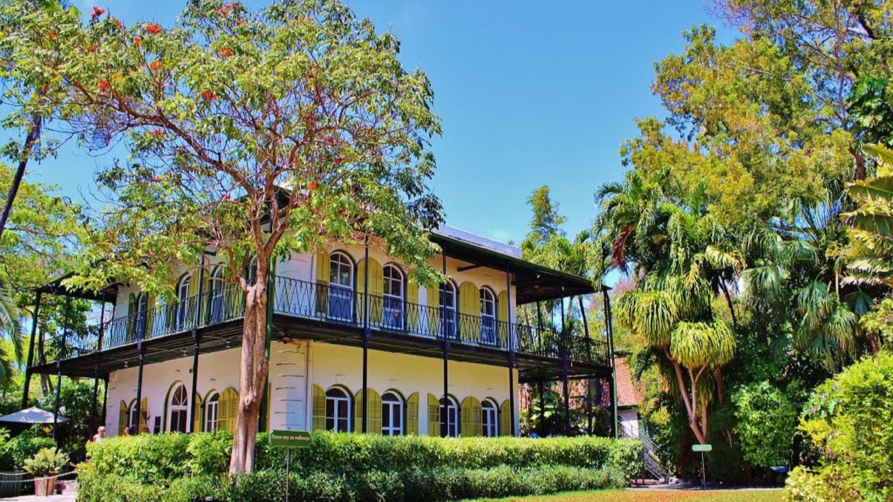 The Ernest Hemingway Home surrounded by tropical gardens and lush greenery in Key West.