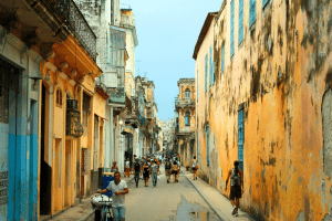 Colorful street in Old Havana with historic buildings, pedestrians, and classic Cuban architecture