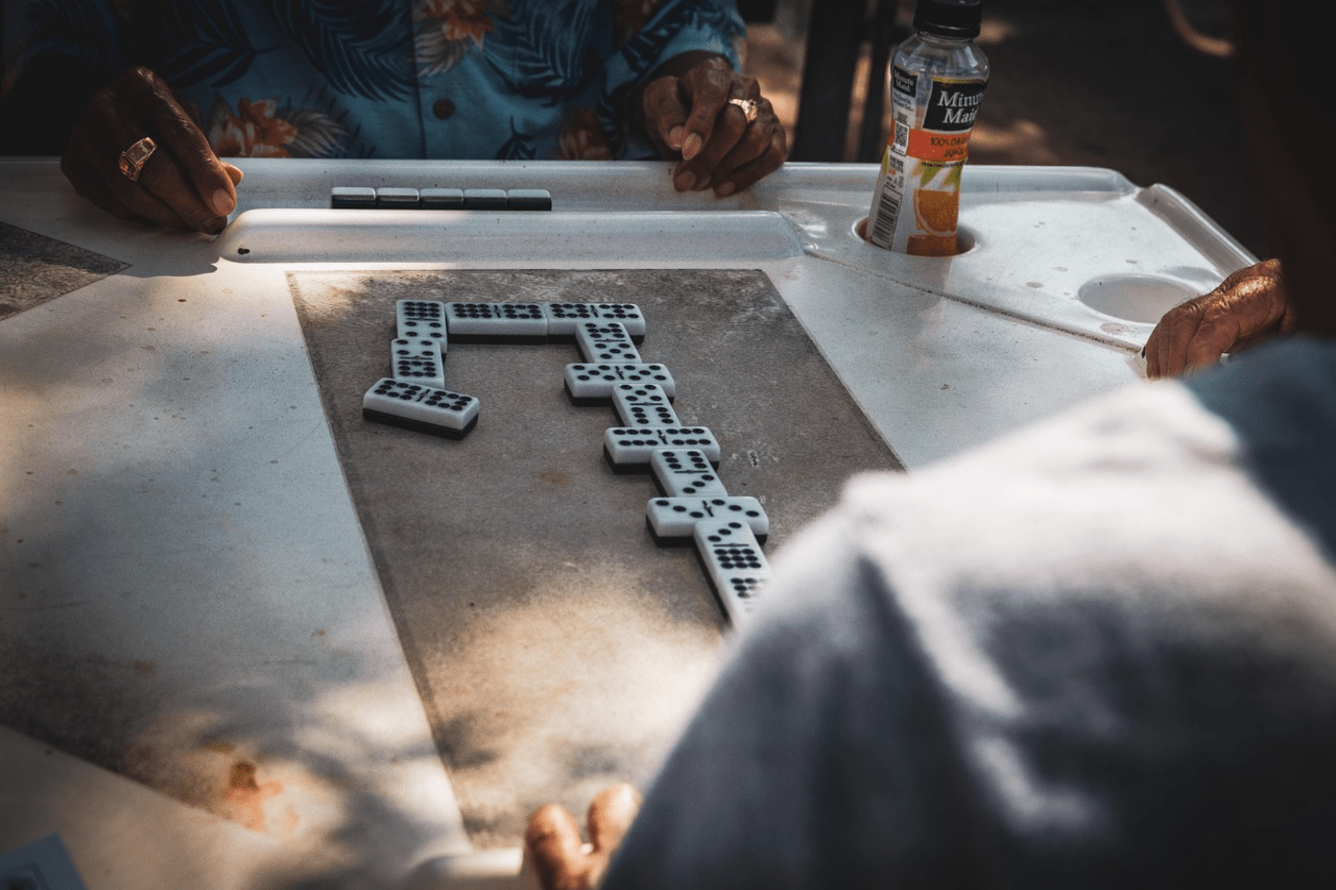 People playing dominoes at a table in Little Havana, a popular Cuban cultural tradition in Miami.