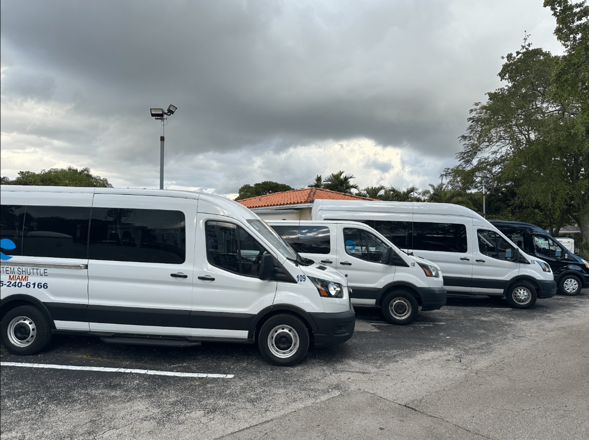 System Shuttle Miami passenger vans parked and ready for airport and city transportation services.