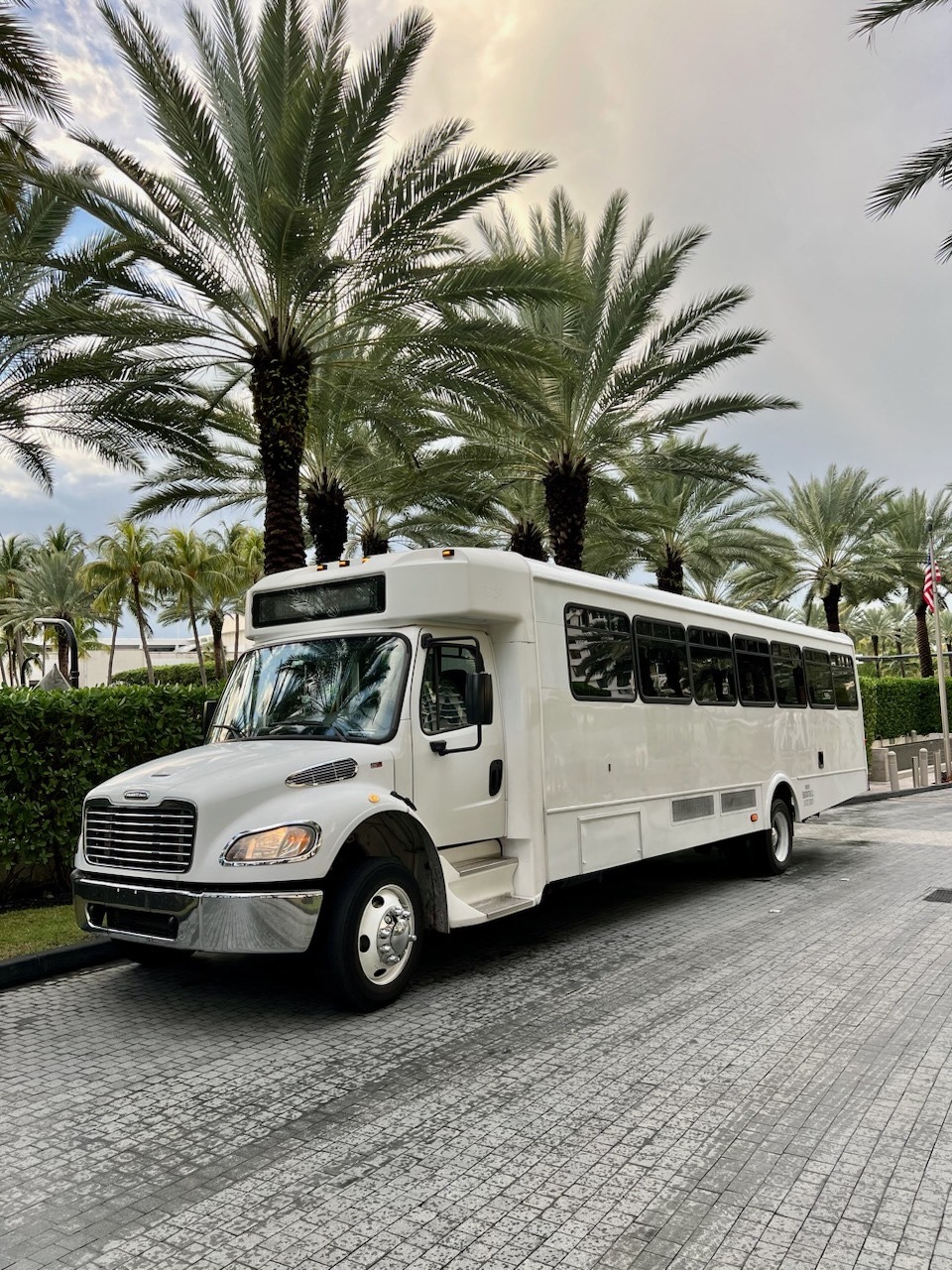 Private charter shuttle bus parked near palm trees, ready for group transportation, airport transfers, and cruise port shuttle services.