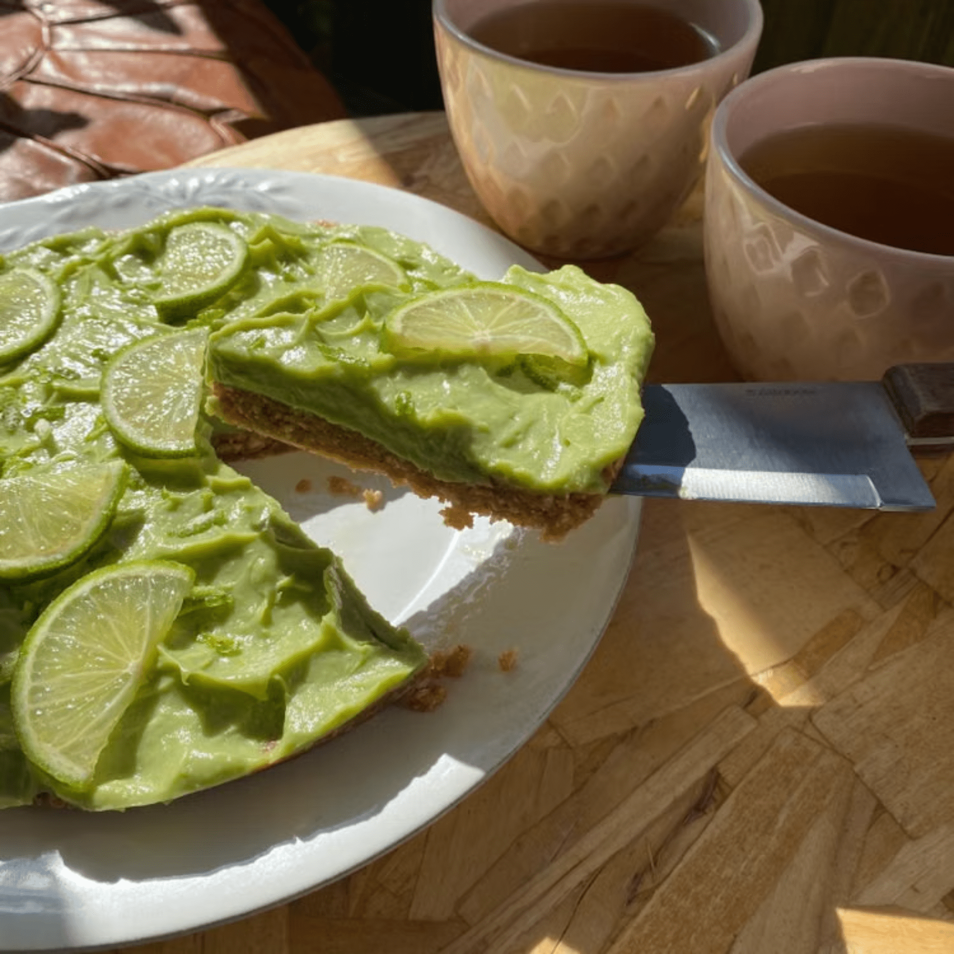 Key lime pie topped with fresh lime slices and served with tea