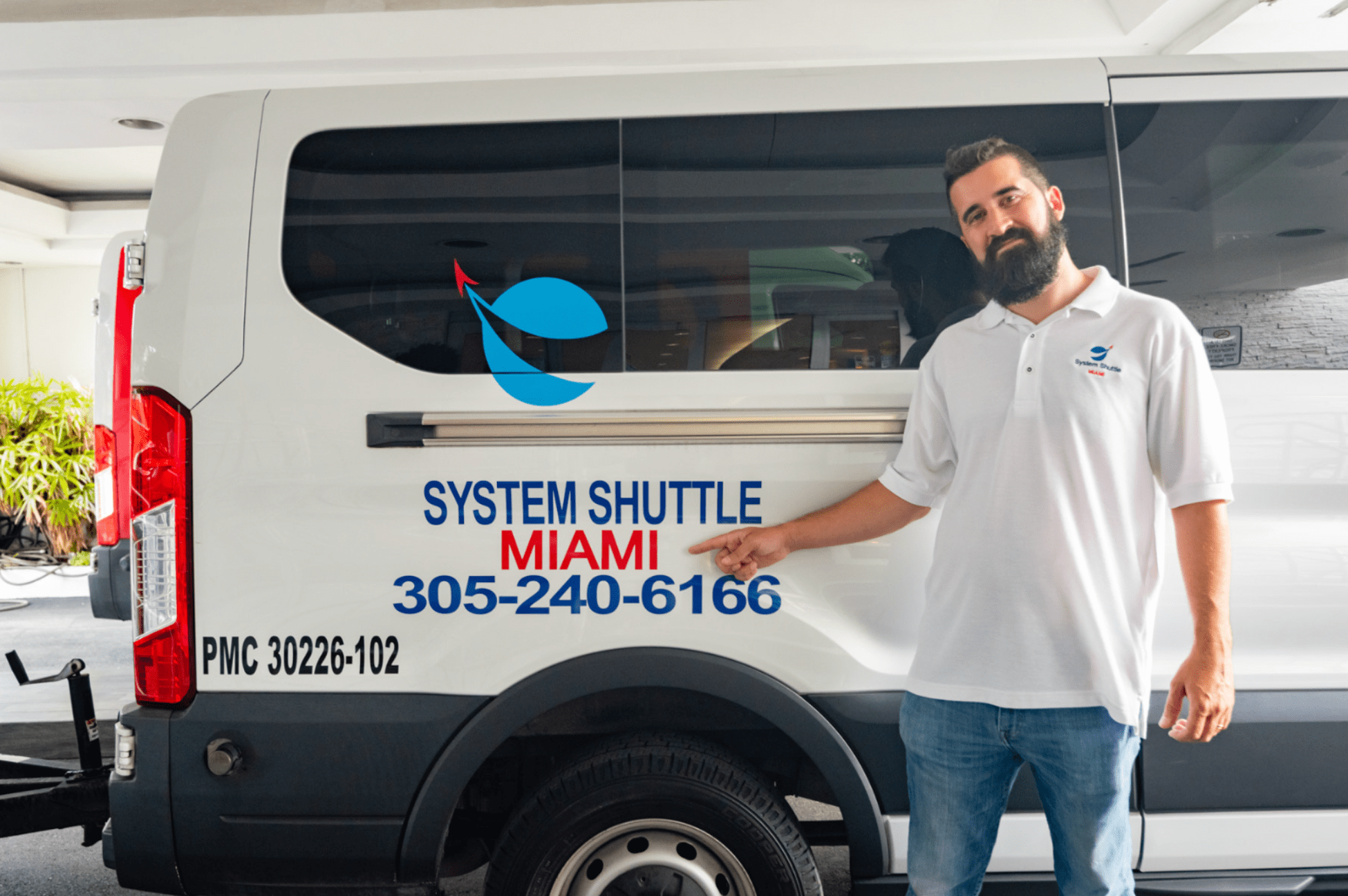 System Shuttle Miami driver standing beside a branded sprinter van.