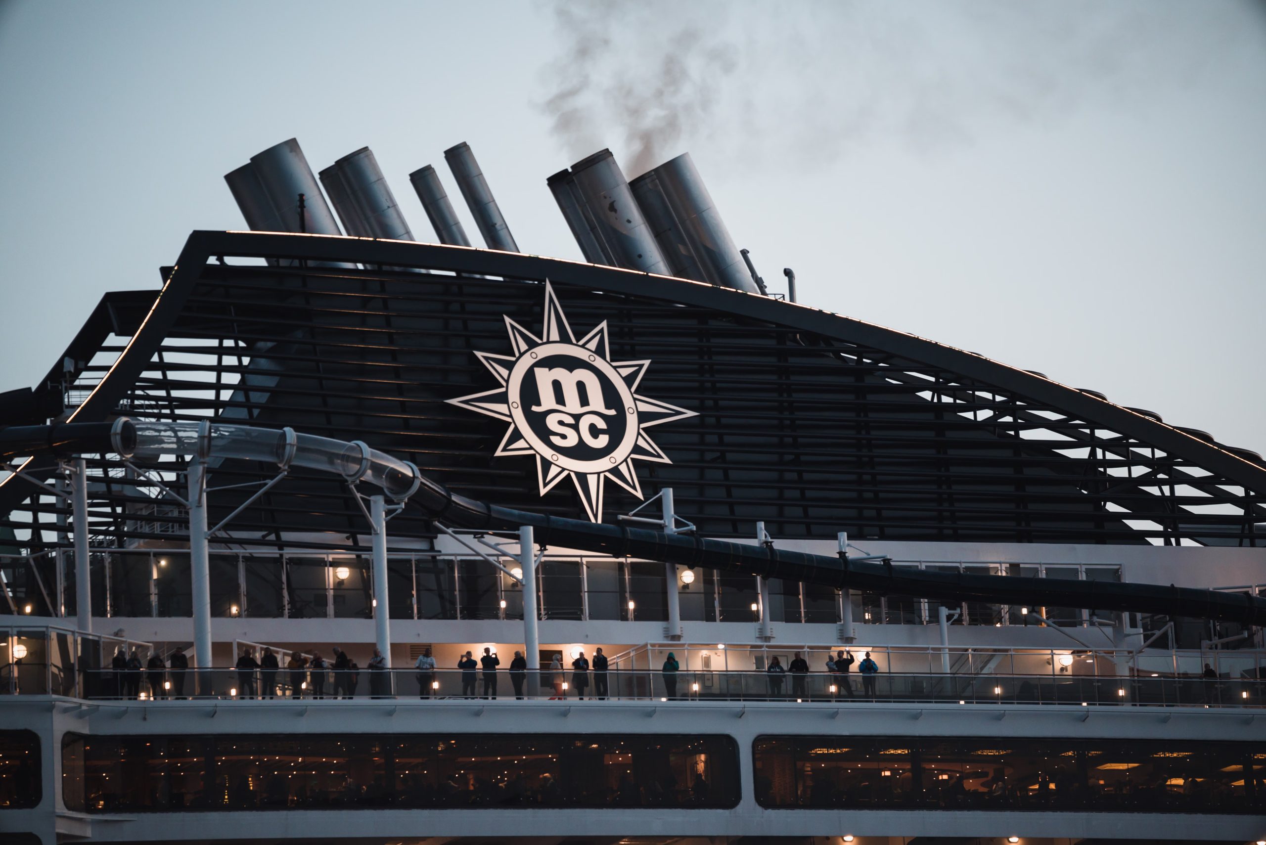 MSC Cruises logo above a cruise ship deck with passengers and waterslide